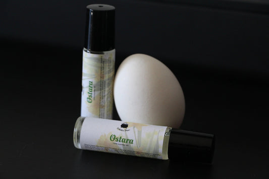 Witches' Brew Ostara essential oil roll-ons and a white egg on a black background