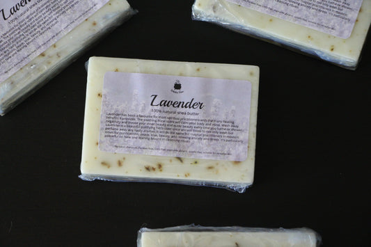 Lavender shea butter soap bars with natural exfoliating particles on black surface