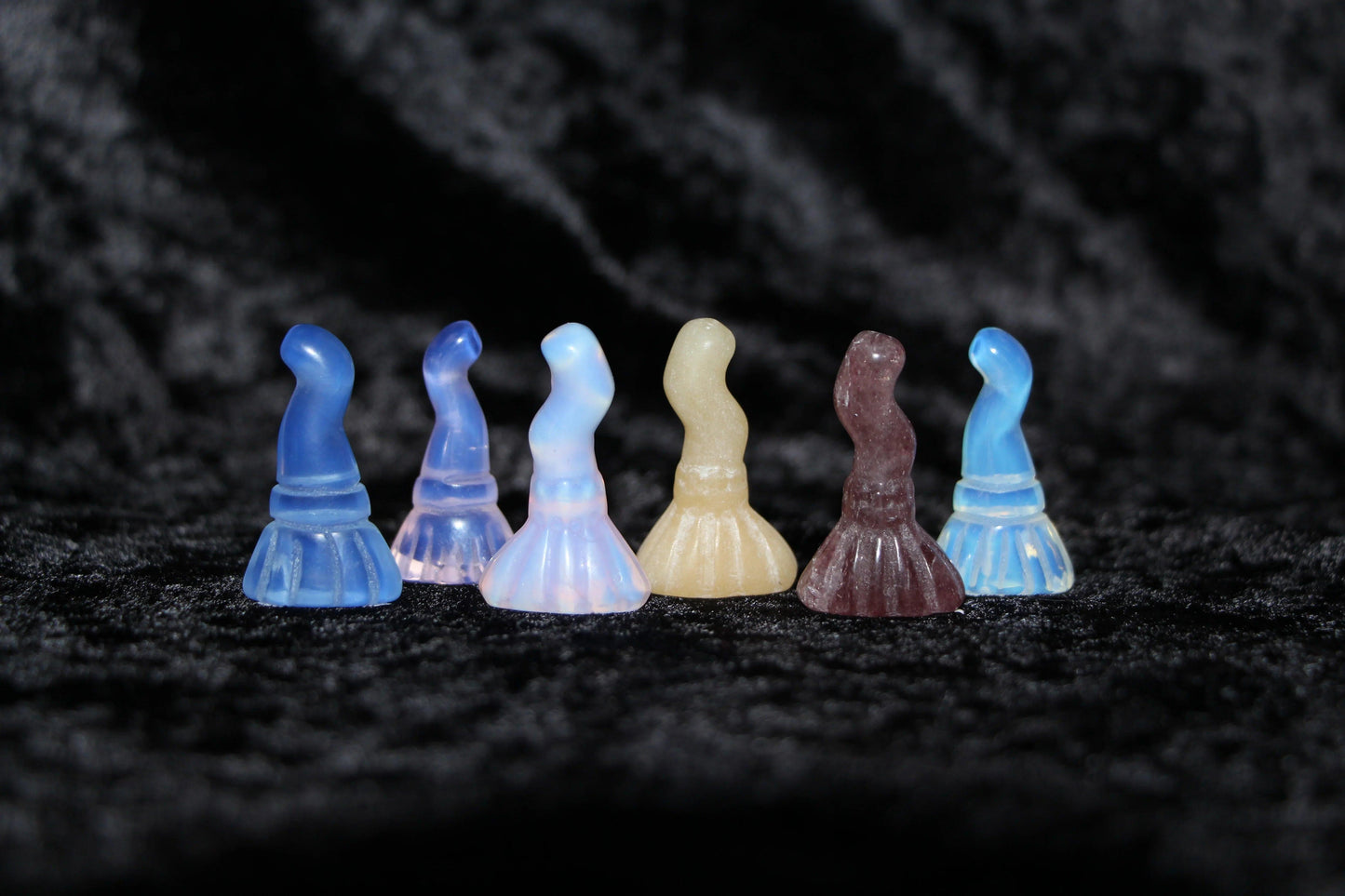Hand-crafted crystal witch hats in various colors on black velvet, modern witch decor