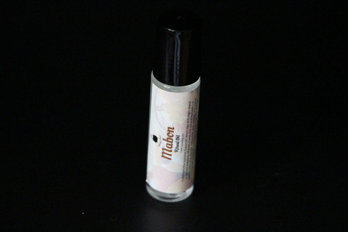 Mabon ritual oil roll-on bottle for modern witch intentions on black background