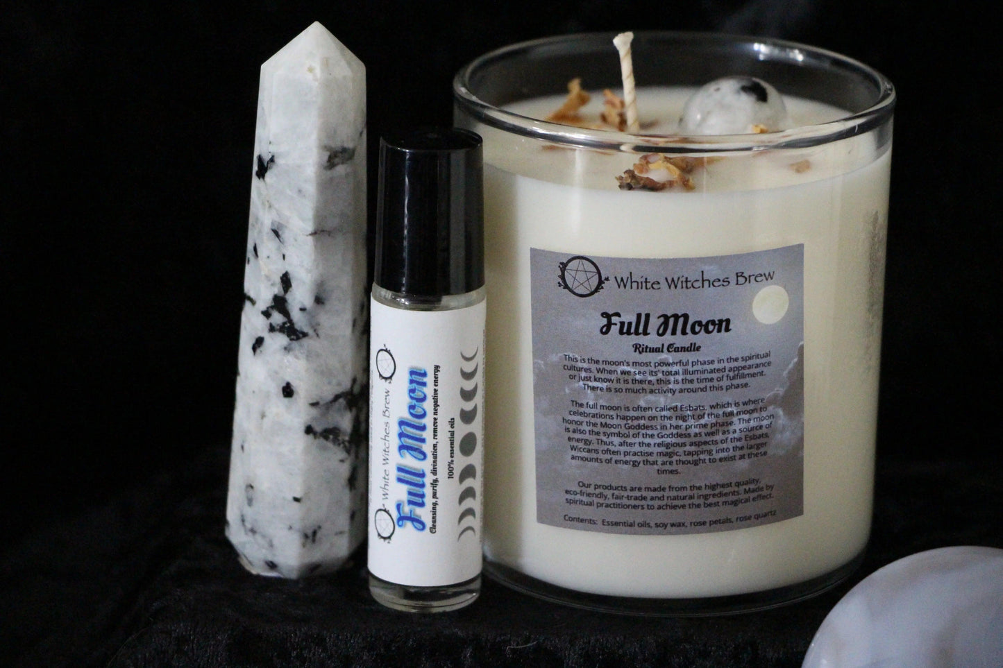 White Witches Brew Full Moon ritual candle with essential oil roller and white-black speckled crystal