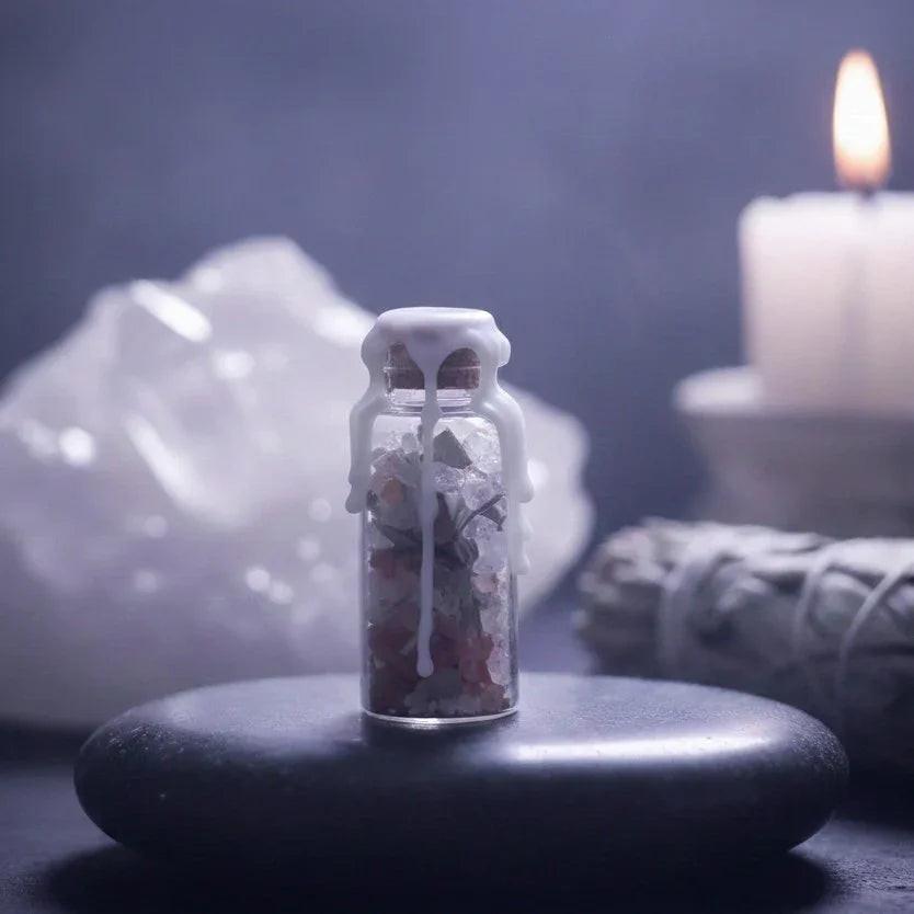 Crystal spell jar with wax seal, white candle, sage bundle, and large crystal in mystical setting