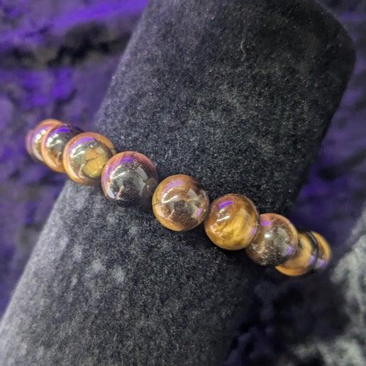 Tiger's eye crystal bracelet with polished round beads on black velvet display