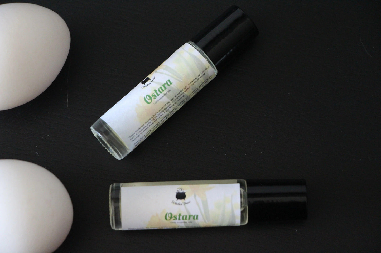 Ostara essential oil roller bottles on black surface, Witches' Brew ritual tools