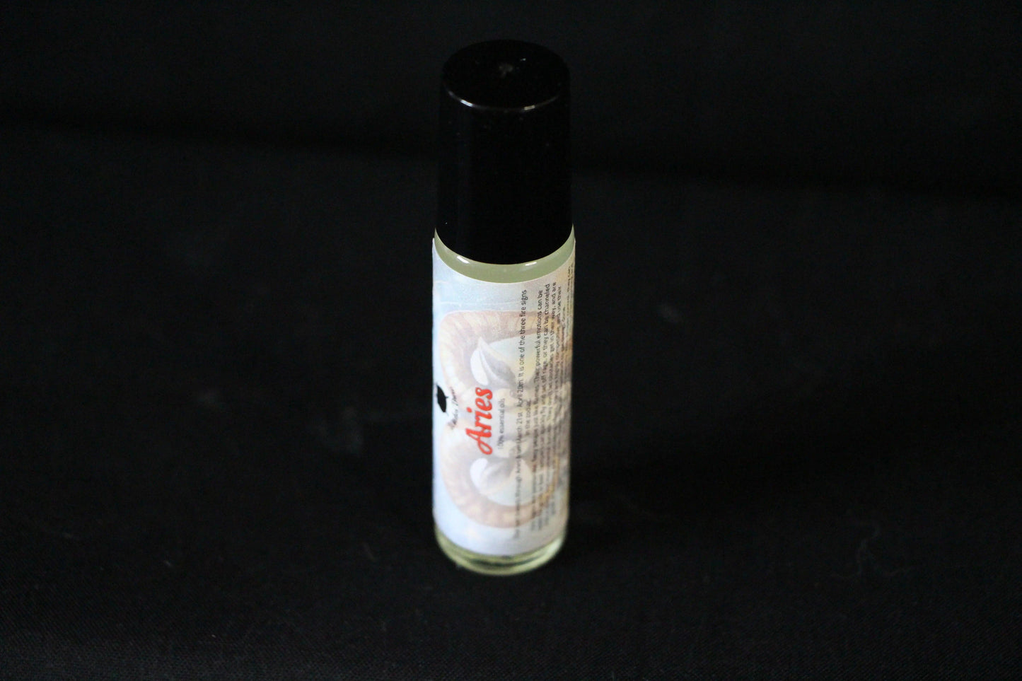 Aries essential oil roll-on with ram graphic on black background, Witches' Brew product