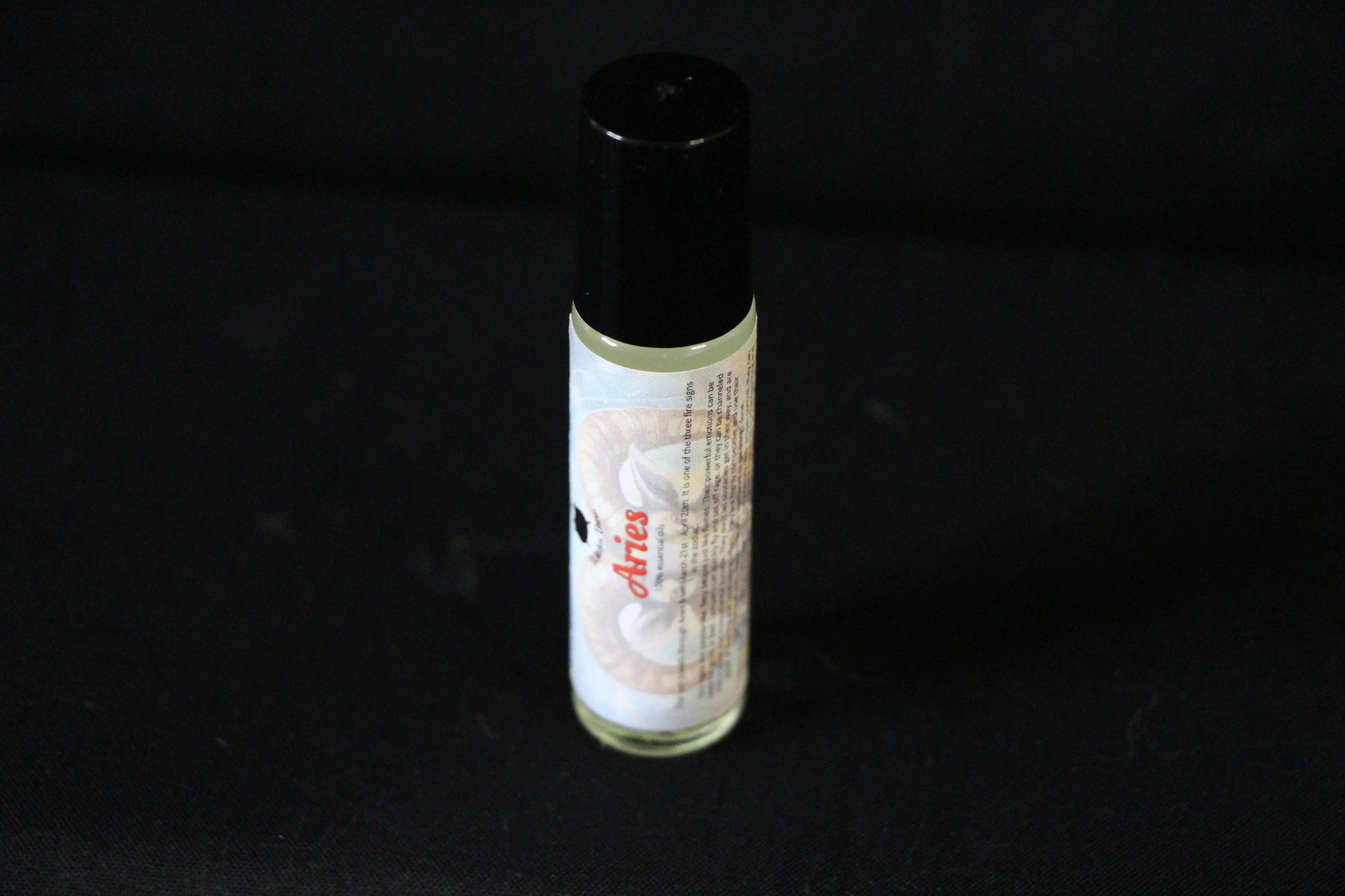 Aries essential oil roll-on with ram graphic on black background, Witches' Brew product