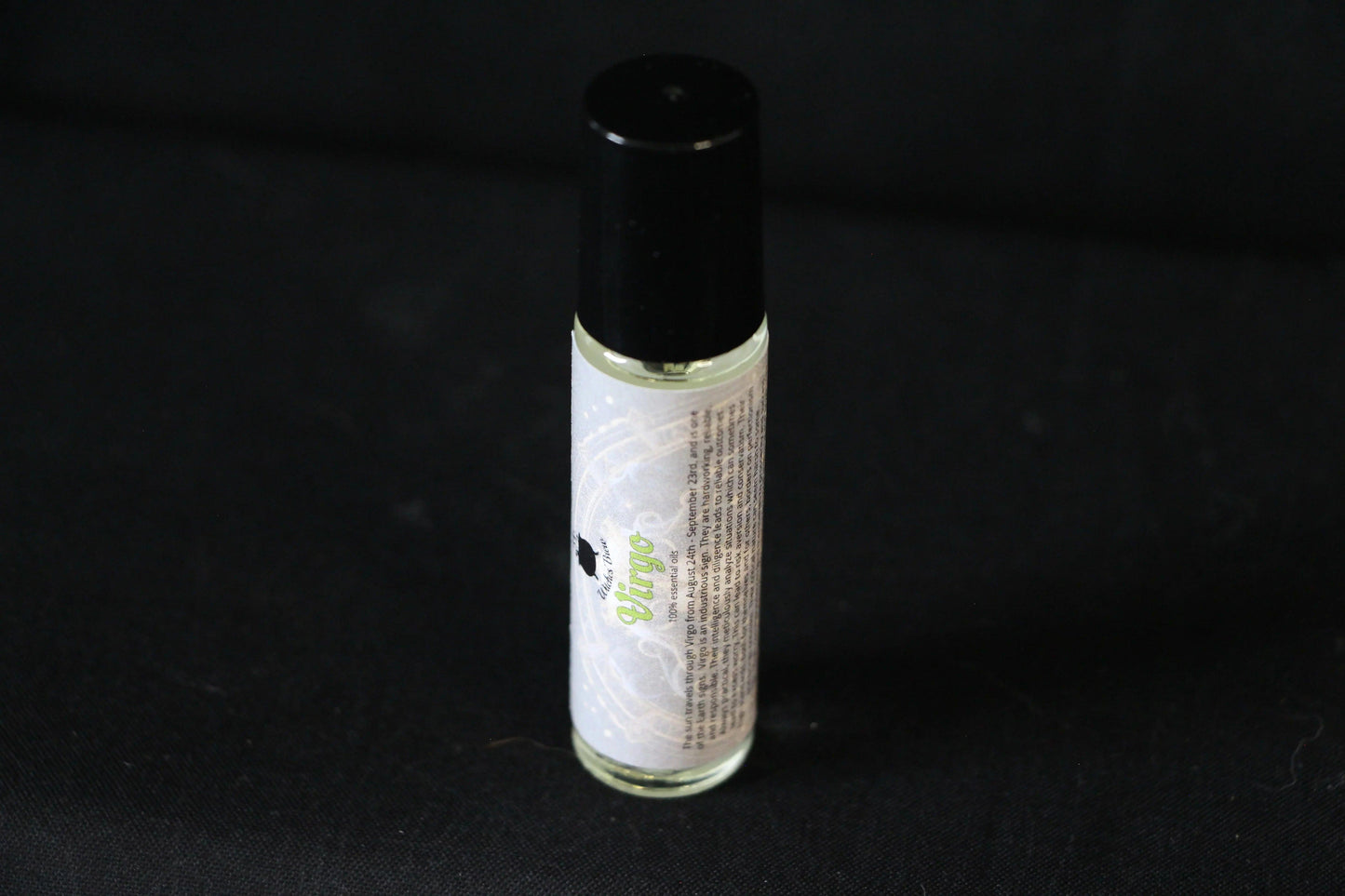 Virgo essential oil roller bottle with black cap on black background, Witches' Brew product