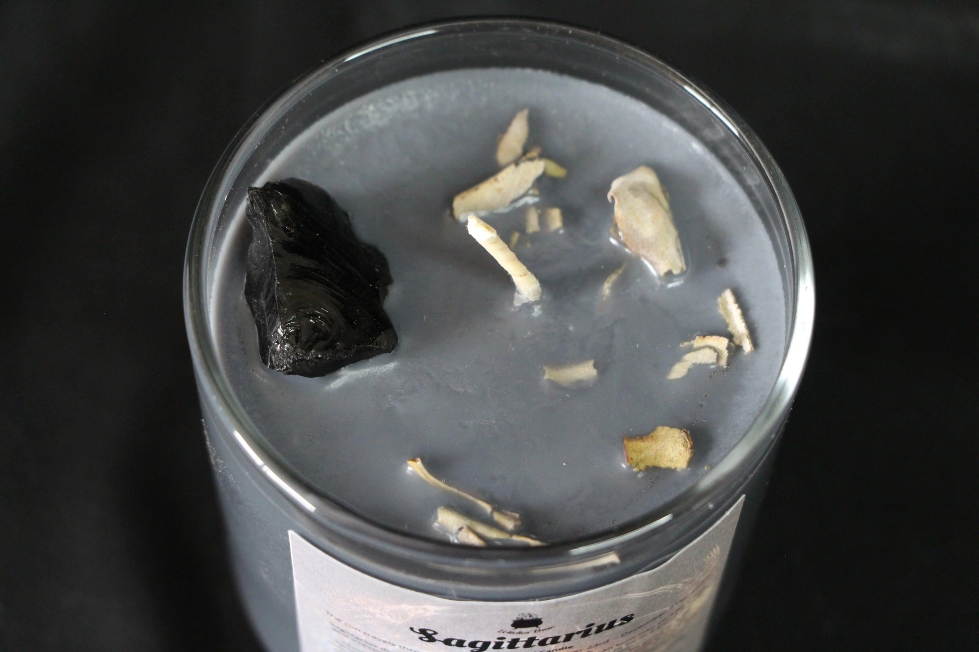 Handcrafted gray crystal candle with herbs and black obsidian for modern witch rituals