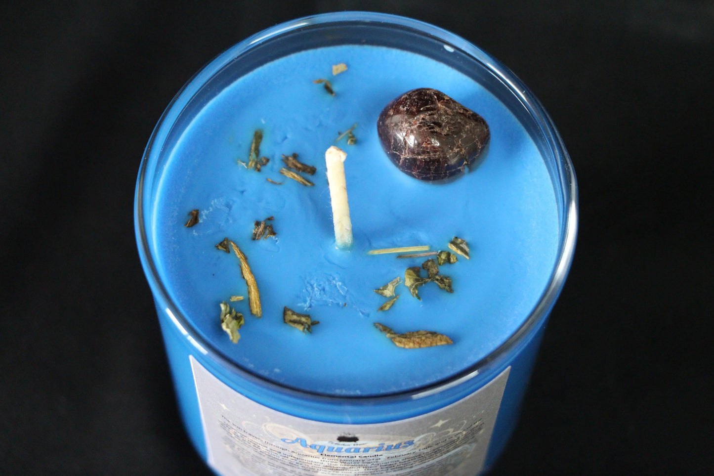 Blue crystal candle with herbs and stone, hand-crafted for modern witch rituals