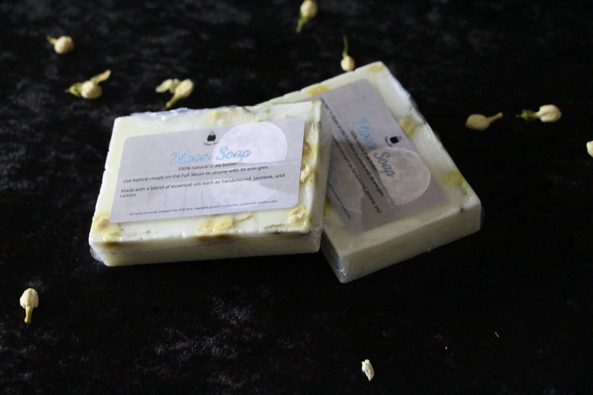Handcrafted Moon Soap bars with jasmine petals on dark velvet, witch ritual products