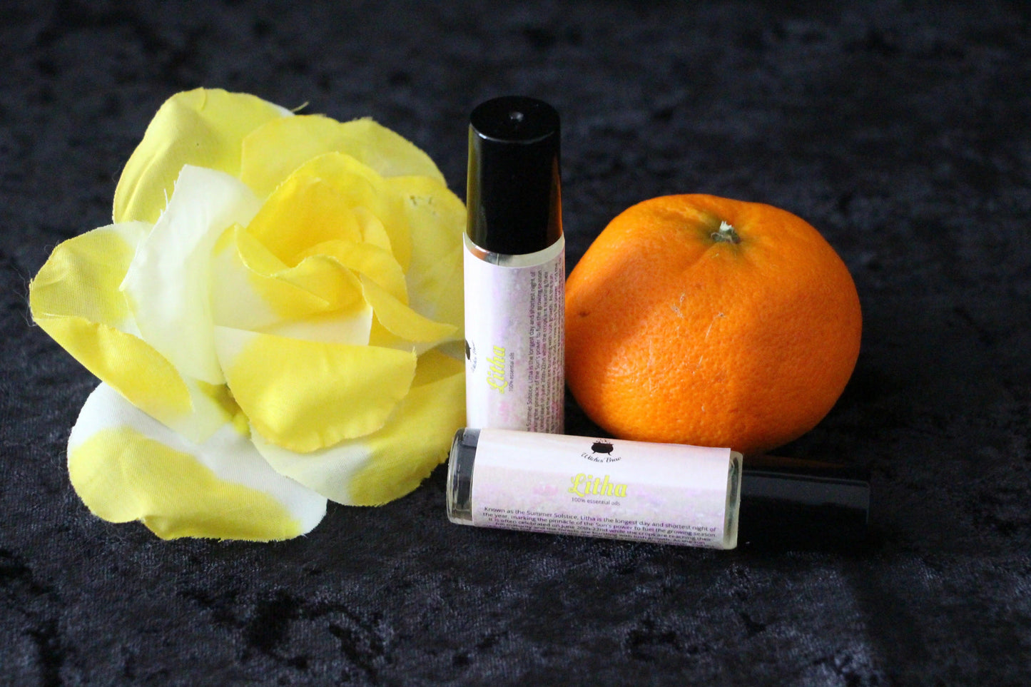 Litha essential oils by Witches' Brew with yellow rose and orange on black background