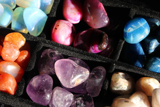 Close-up of polished multicolored gemstone collection in black velvet display case
