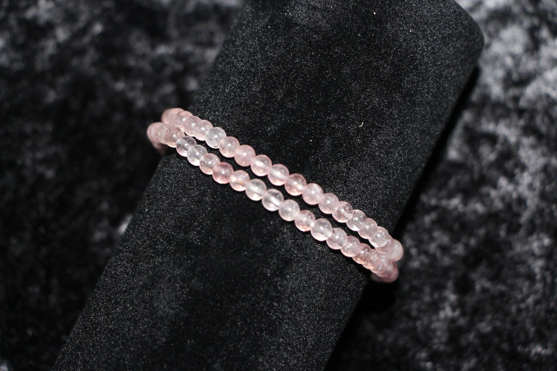 Rose quartz crystal bead bracelets displayed on black velvet