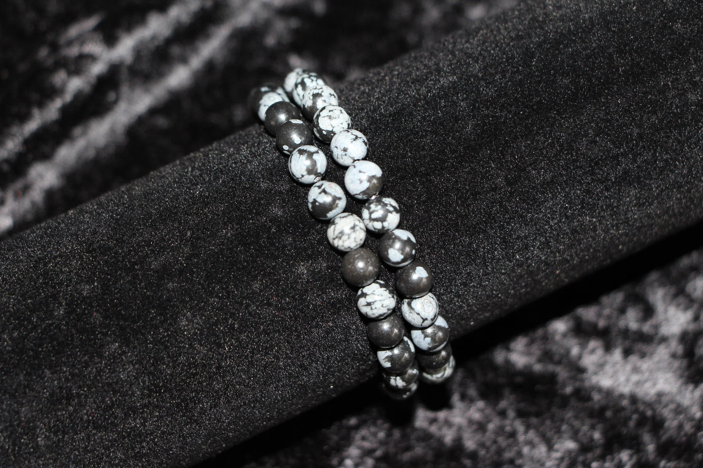 Snowflake obsidian crystal bead bracelet on black velvet display
