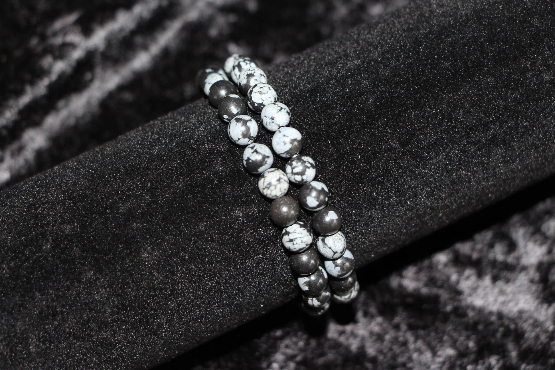 Snowflake obsidian crystal bead bracelet on black velvet display