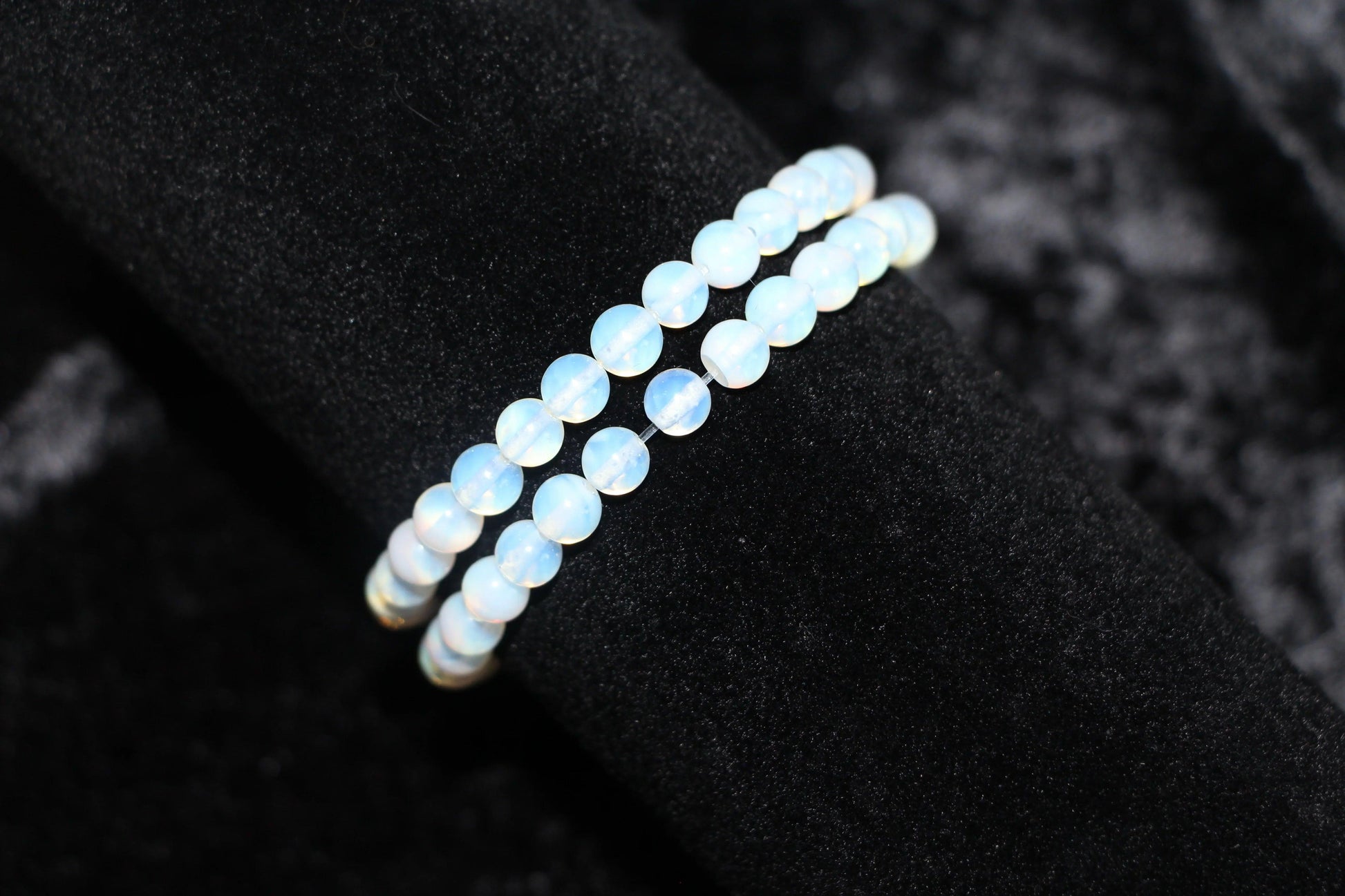 Opalite crystal bead bracelet on black velvet background