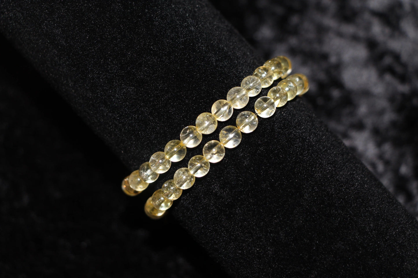 Double strand yellow crystal bead bracelet on black velvet background