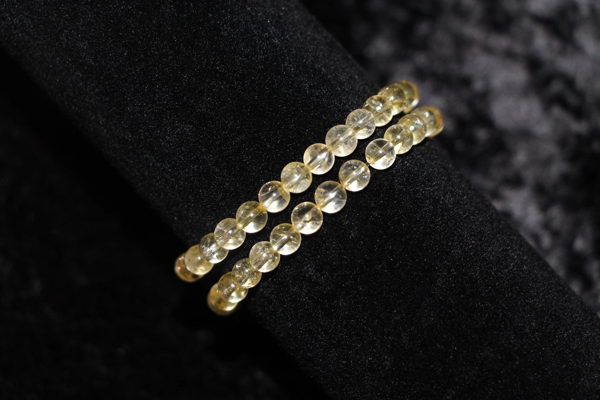 Double strand yellow crystal bead bracelet on black velvet background