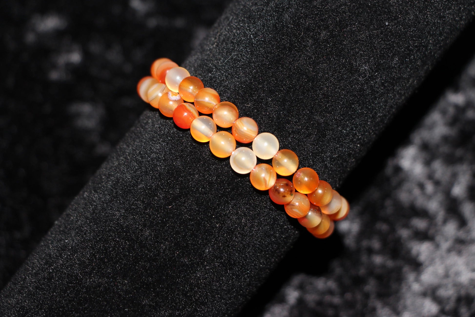Carnelian crystal bead bracelet on black velvet display, handmade gemstone jewelry