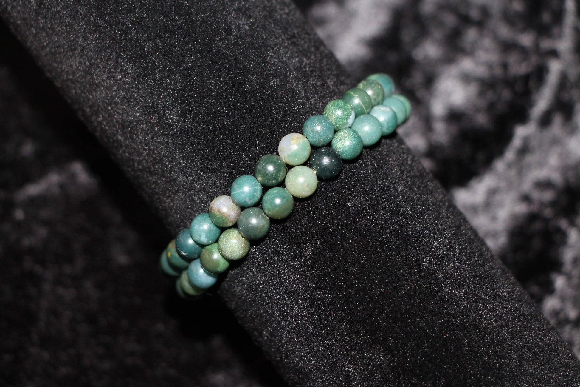 Green crystal bead bracelet on black velvet background, handcrafted jewelry