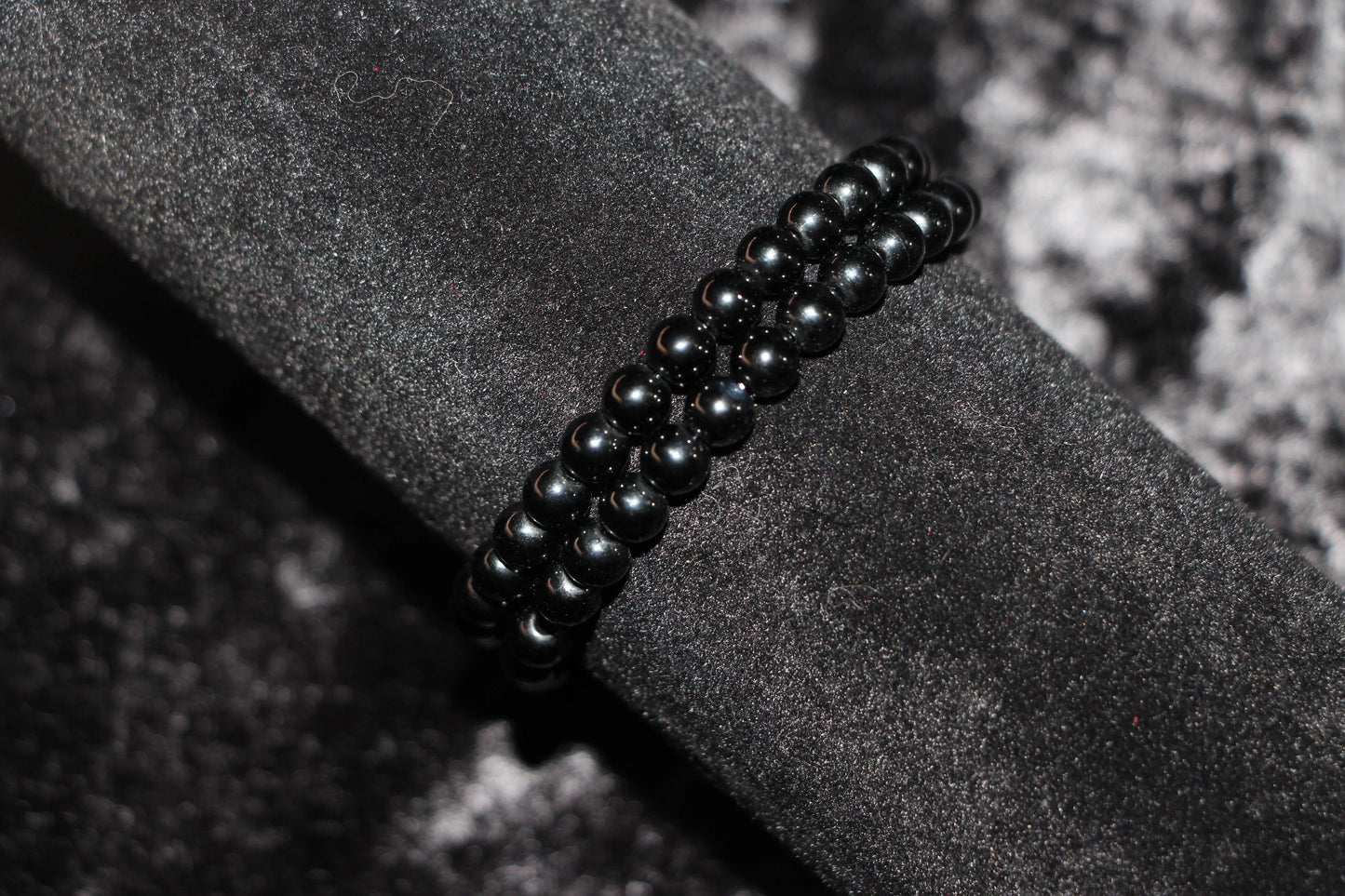 Black crystal beaded bracelet on dark velvet background, witchy jewelry accessory