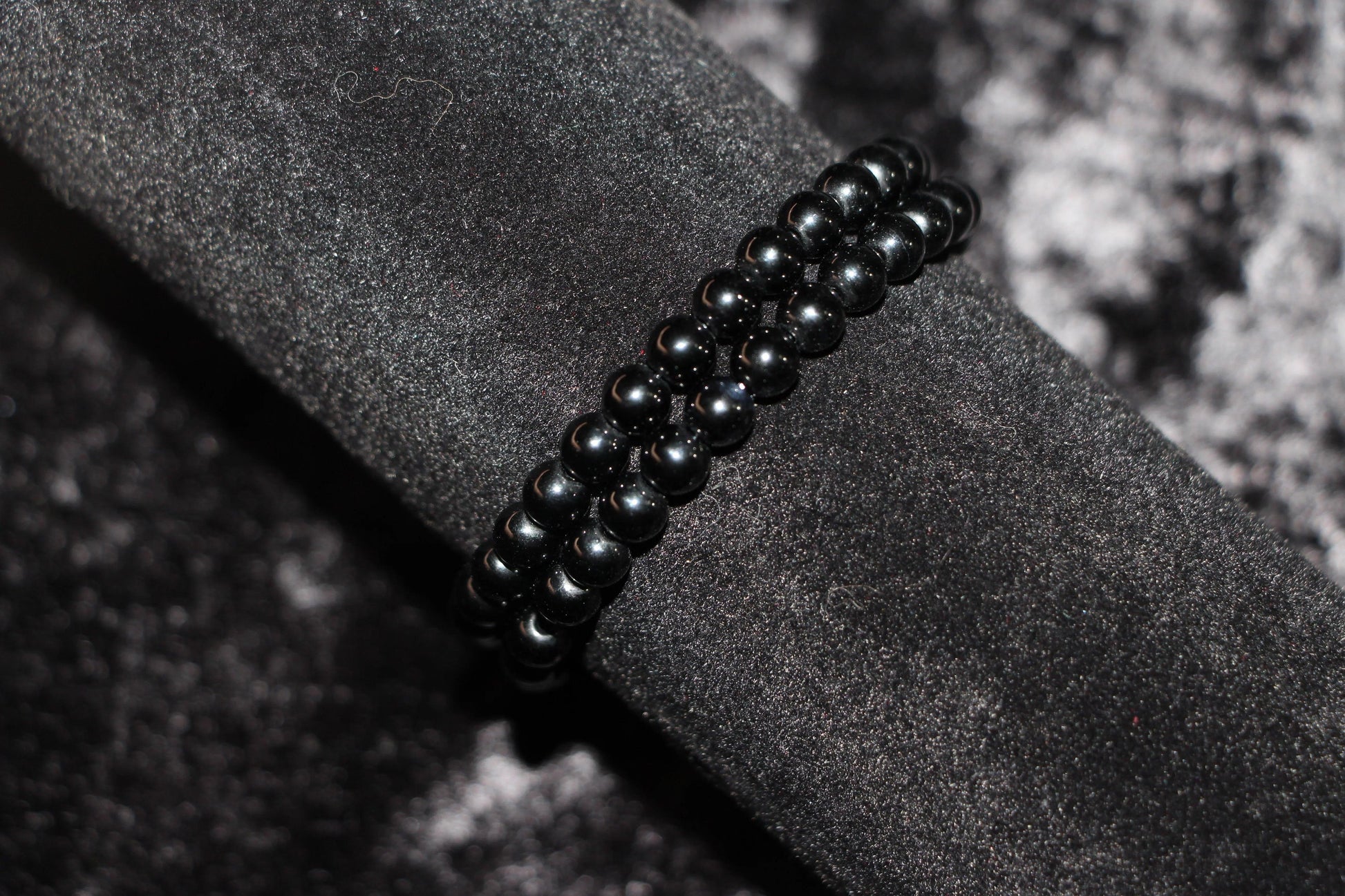 Black crystal beaded bracelet on dark velvet background, witchy jewelry accessory