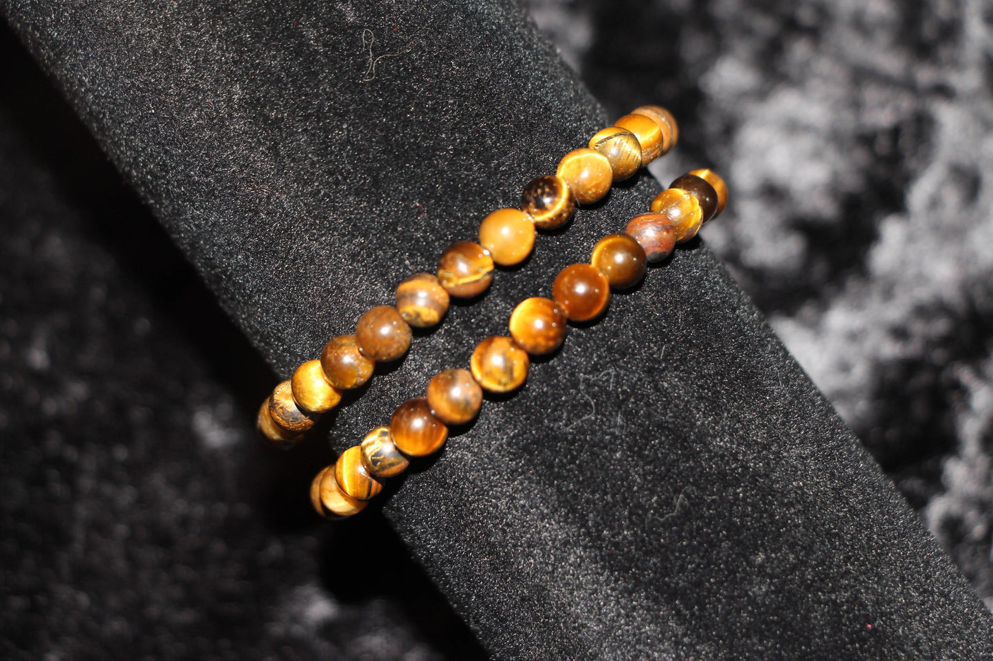 Tiger’s eye crystal bead bracelets on black velvet, gemstone jewelry for rituals