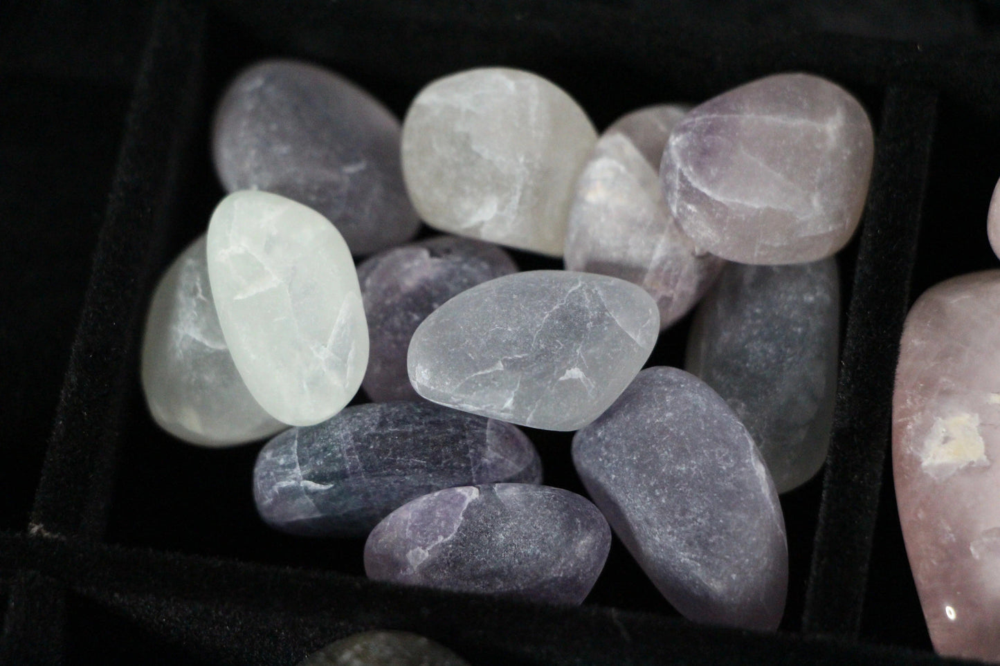 Polished amethyst and quartz crystals in a black velvet tray for modern witch rituals