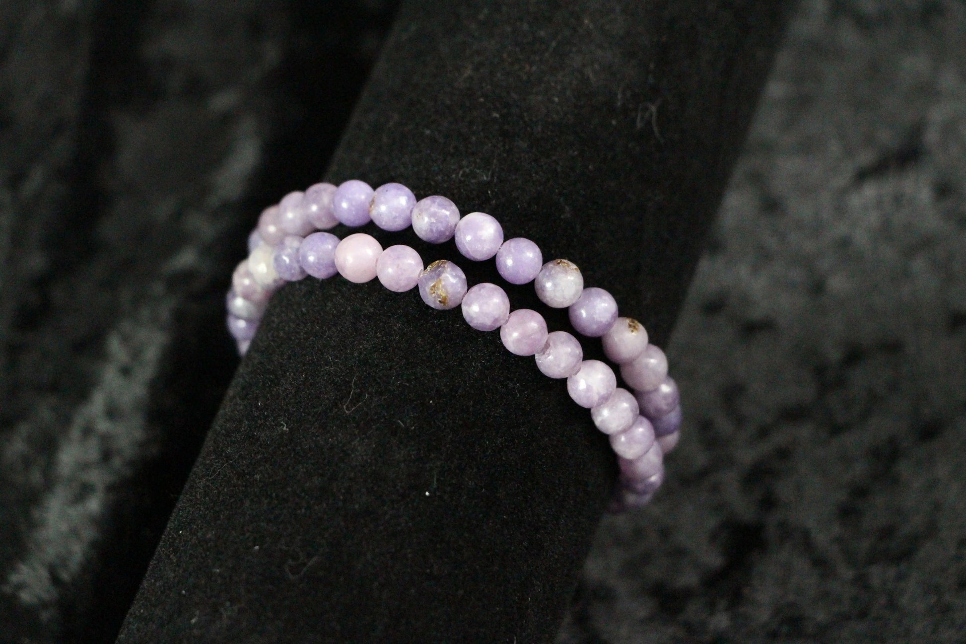 Lavender crystal beaded bracelet on black velvet display, spiritual jewelry