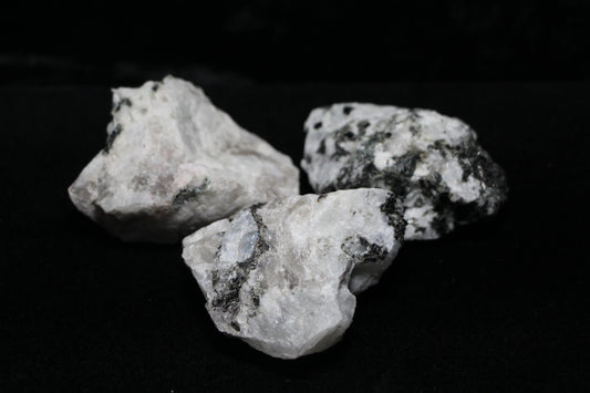 Raw moonstone crystals with black inclusions on black background, Witches' Brew ritual tools
