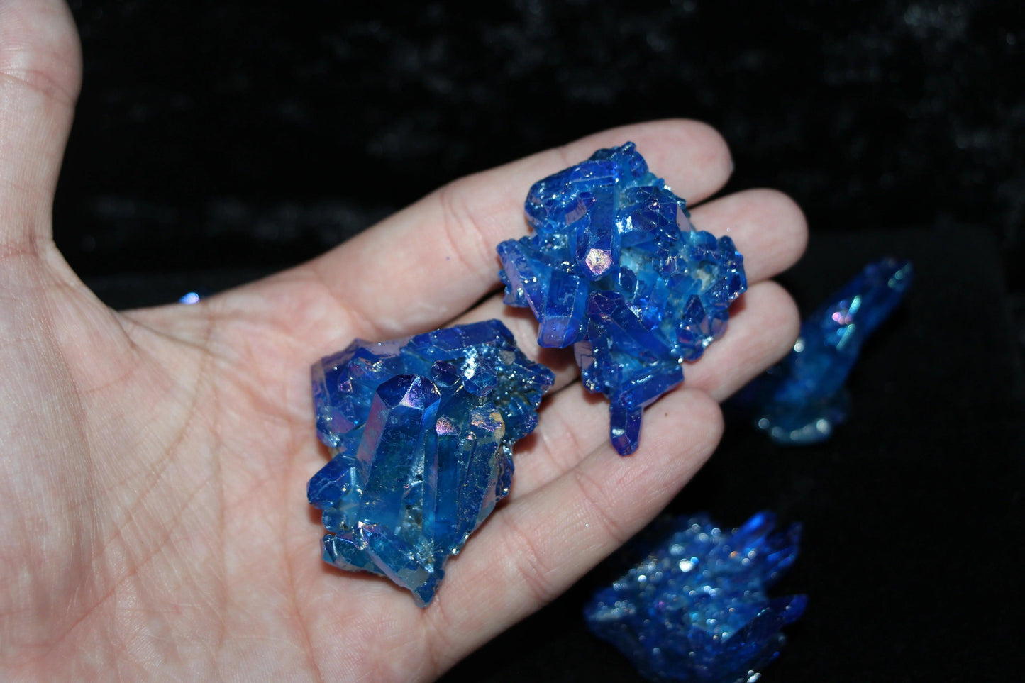 Hand holding vibrant blue crystal clusters for spiritual rituals or home decor
