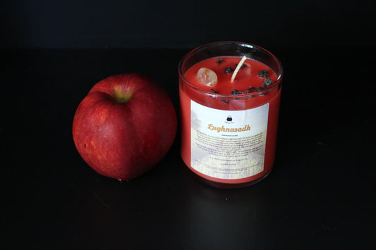 Red apple and Lughnasadh crystal candle on black background, Witches' Brew sustainable handmade decor