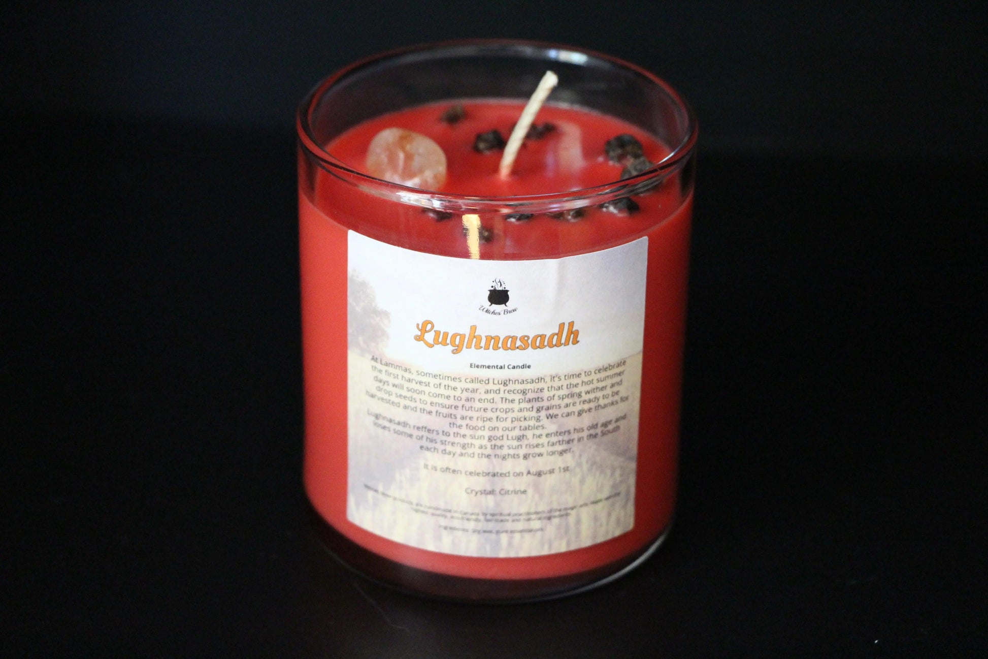 Handmade red Lughnasadh crystal candle with herbs and citrine, Witches' Brew shop.