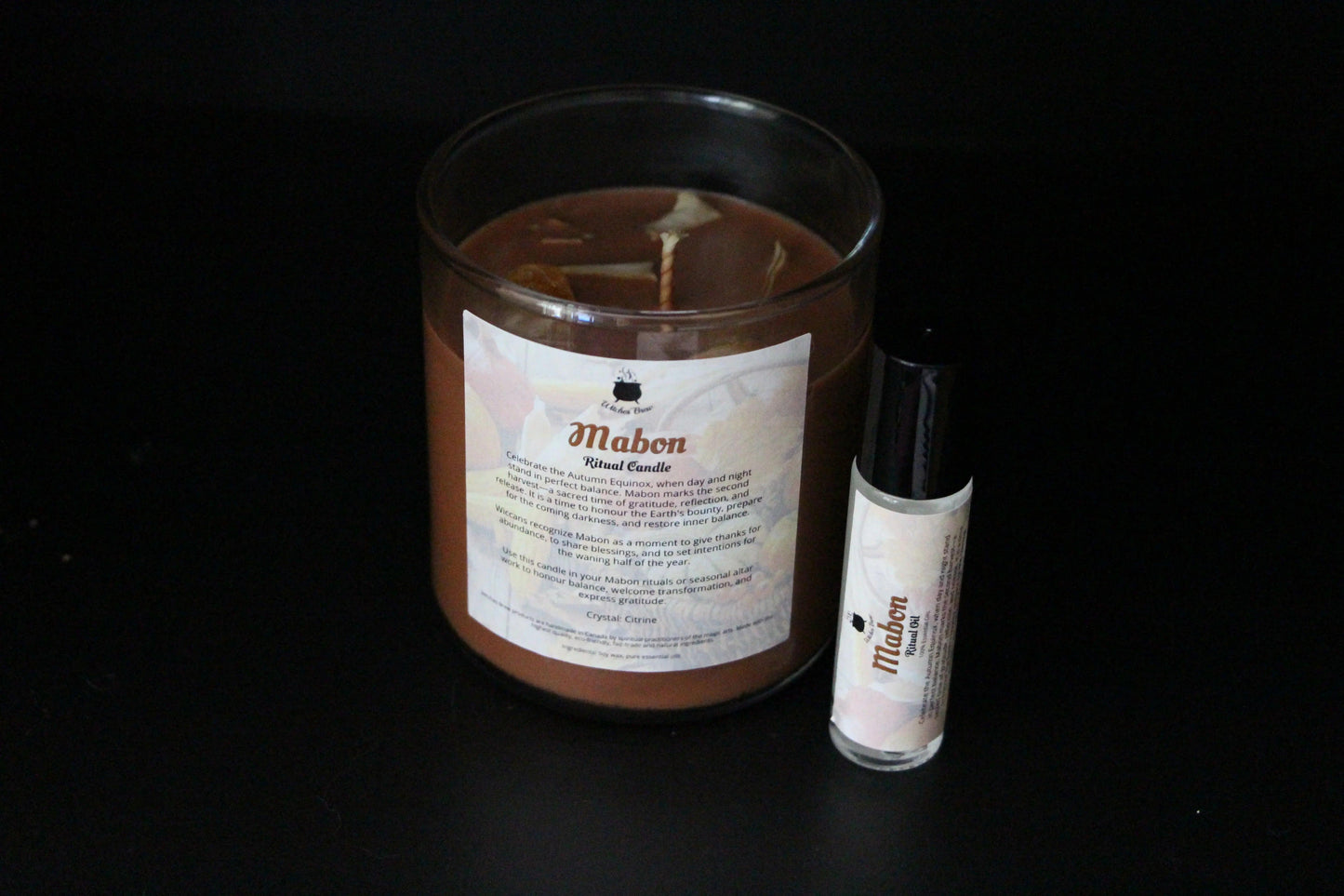 Mabon ritual candle and essential oil on black background, sustainable witchcraft products