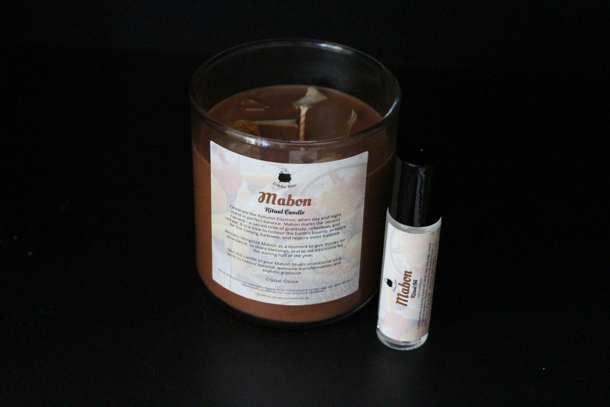 Mabon ritual candle and essential oil on black background, sustainable witchcraft products