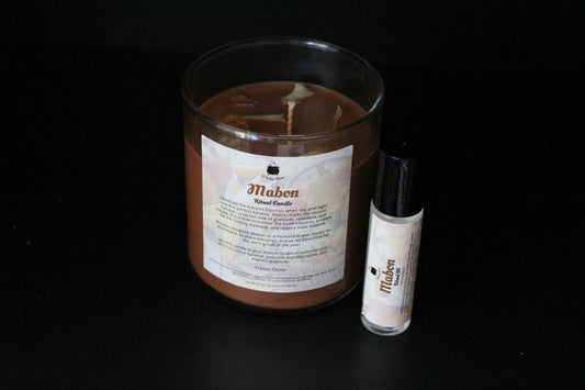 Mabon ritual candle and essential oil on black background, sustainable witchcraft products