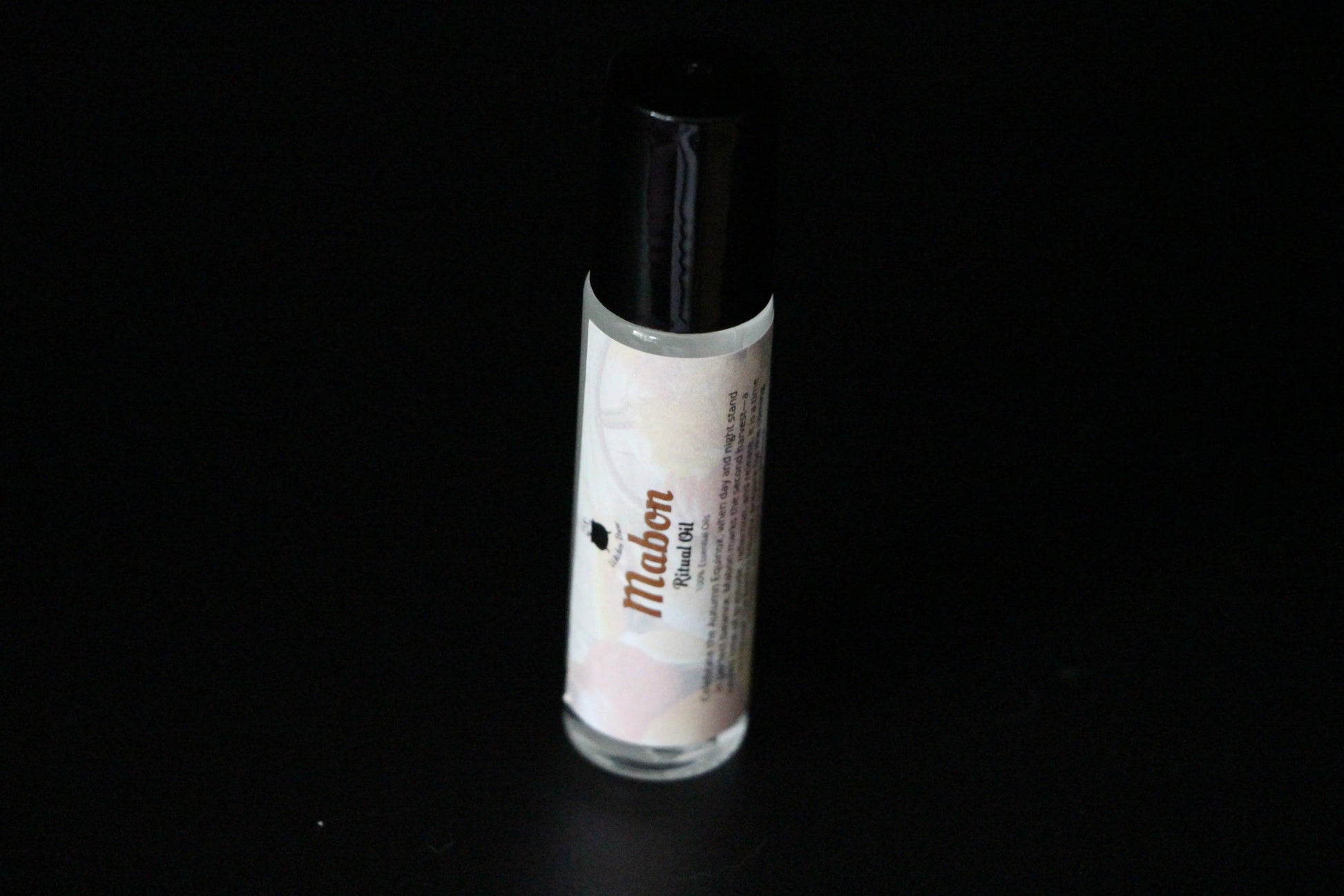 Mabon ritual oil roll-on bottle for modern witch intentions on black background