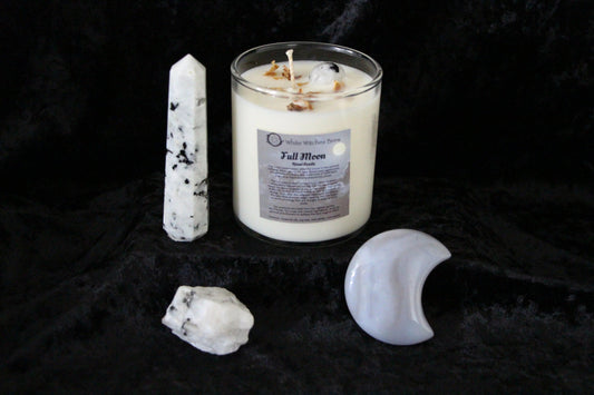 Full Moon ritual candle with moonstone crystal points on black velvet background