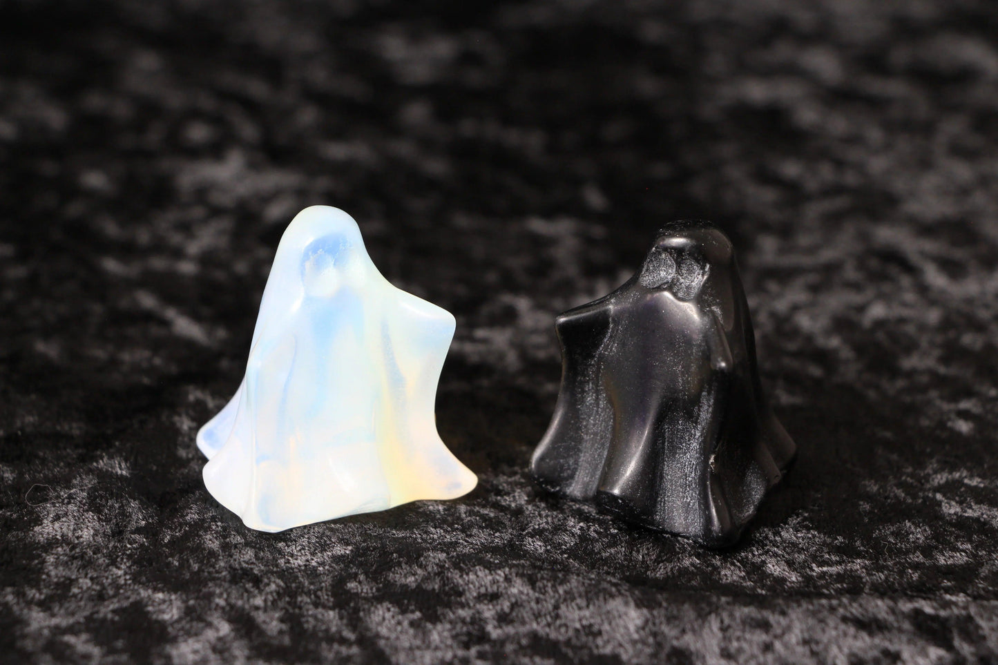 Opalite and black crystal ghost figurines on black velvet background