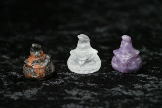 Crystal witch figurines in orange, clear, and purple on black velvet, Witches' Brew decor