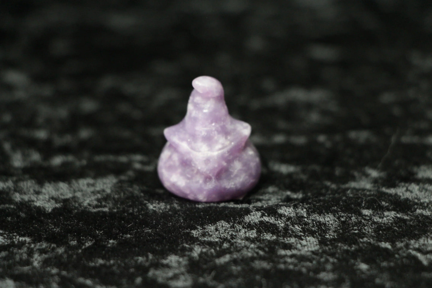 Lepidolite witch hat crystal carving on black velvet, modern witch ritual decor