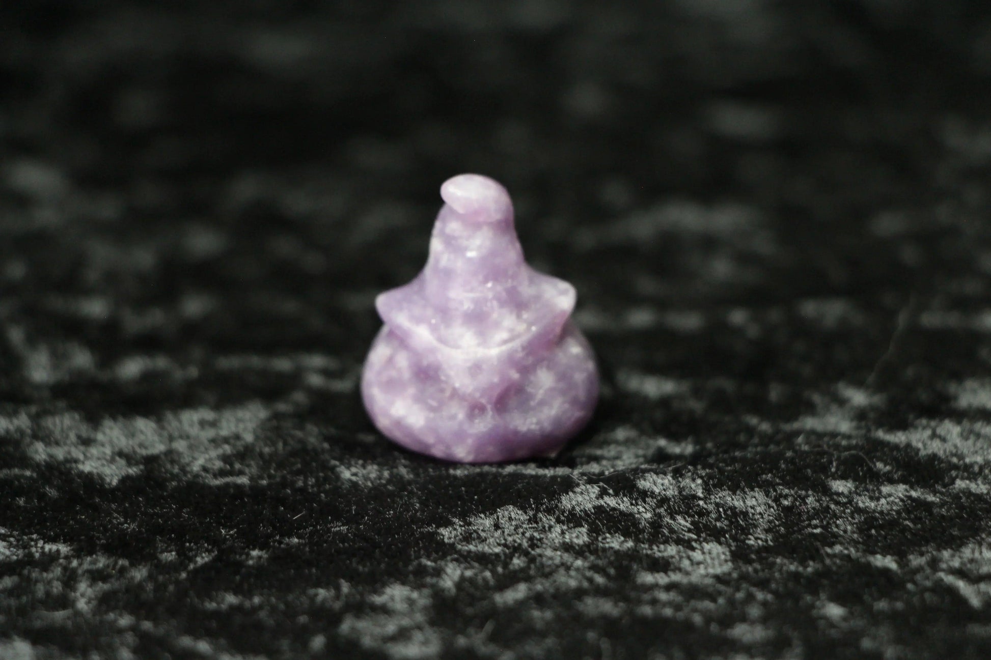 Lepidolite witch hat crystal carving on black velvet, modern witch ritual decor