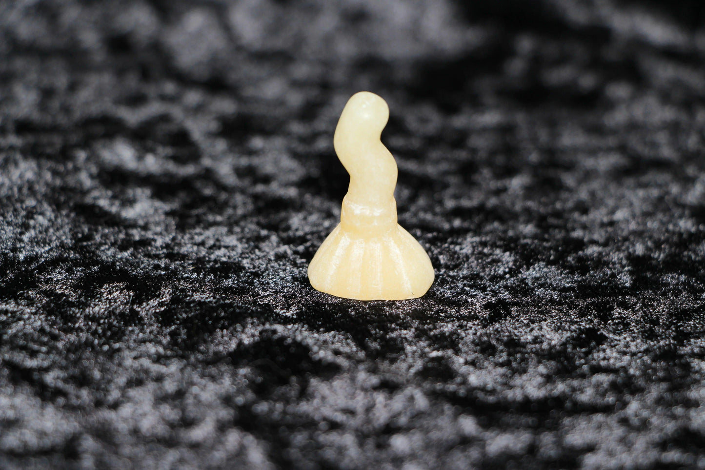 Polished orange calcite crystal figurine on black velvet, Witches' Brew ritual decor
