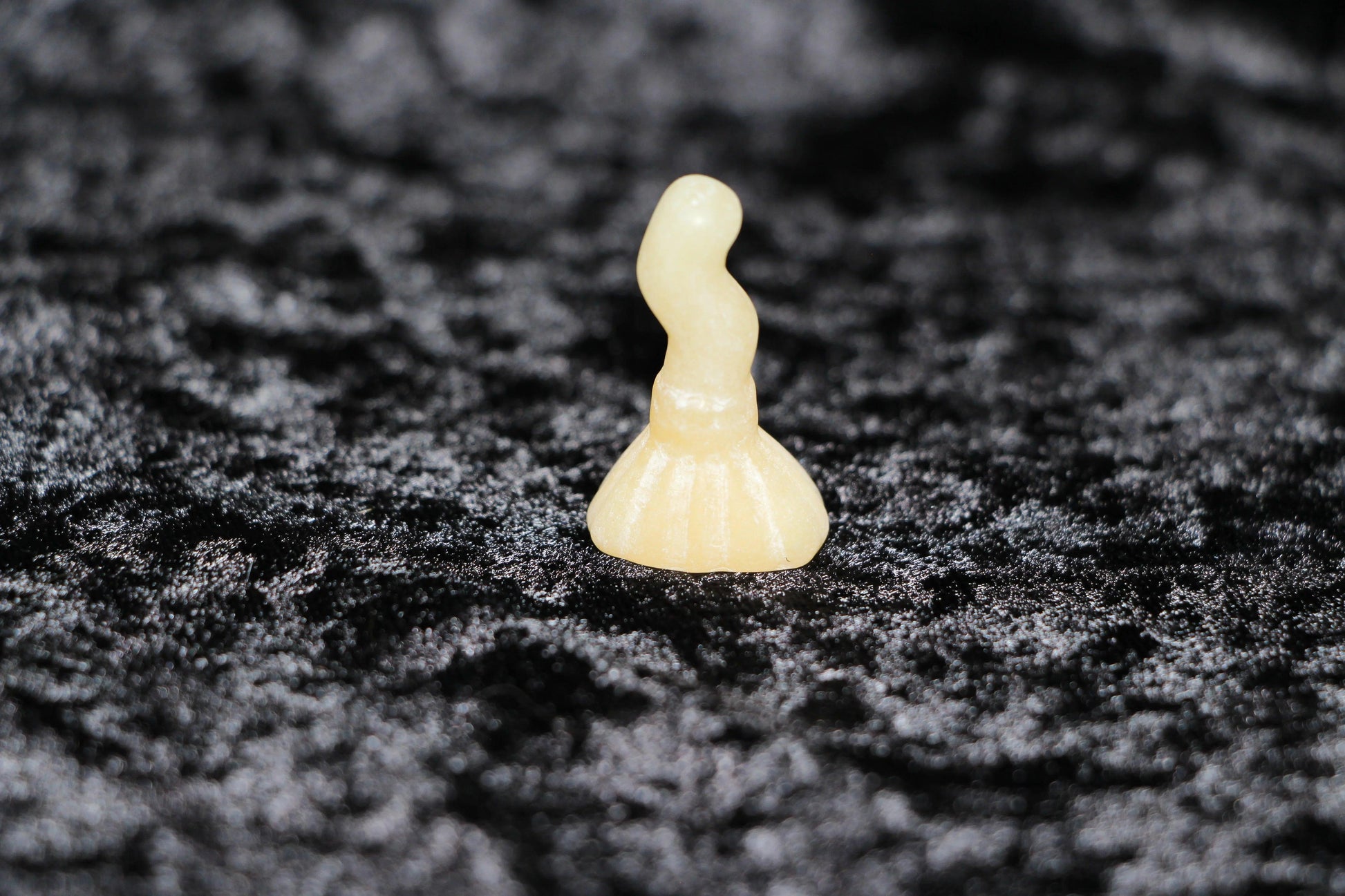 Polished orange calcite crystal figurine on black velvet, Witches' Brew ritual decor