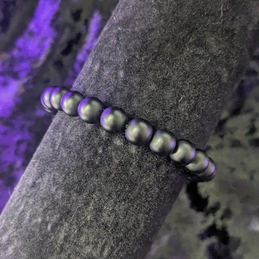 Onyx bead bracelet for ritual or crystal healing on black velvet display