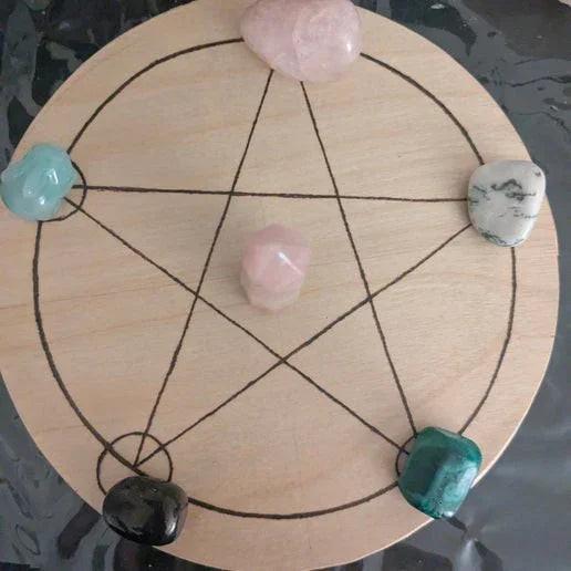 Crystal grid with polished stones on a wooden pentagram for modern witch rituals